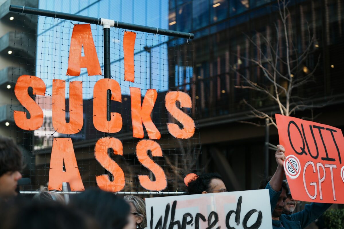 Protestors hold signs against ai and gpt