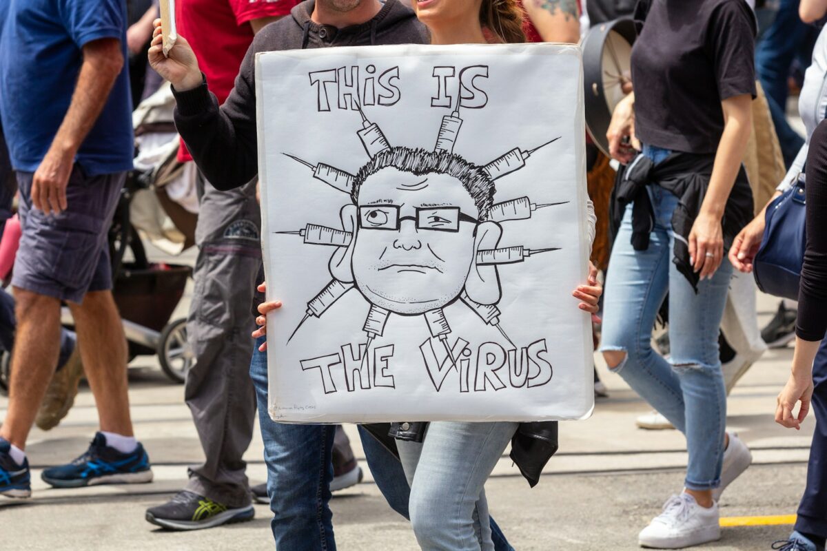 a woman holding a sign that says this is the weird